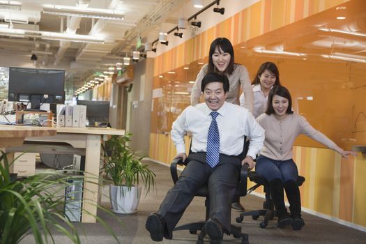 Businesswomen Pushing Her Colleagues in the Chair
