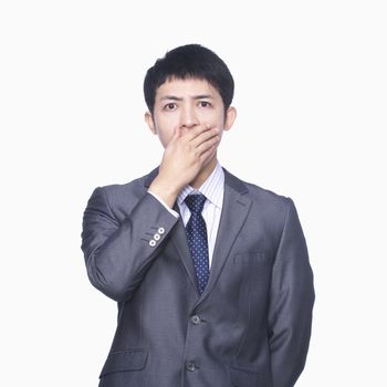 Businessman covering mouth with hand