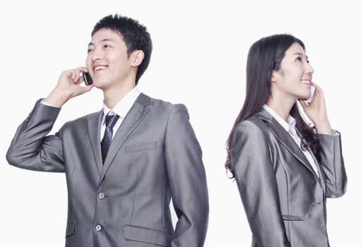Businessman and businesswoman talking on cell phone