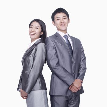 Businessman and businesswoman standing back to back
