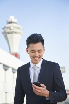 Traveler looking at cell phone message at airport