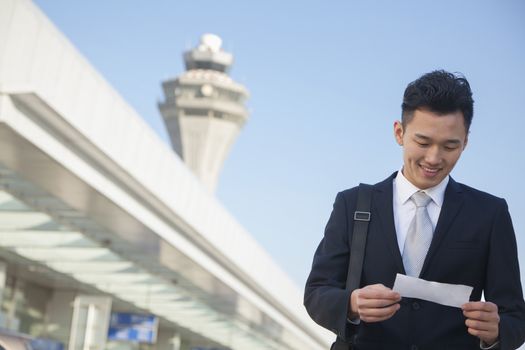 Traveler looking at ticket at airport