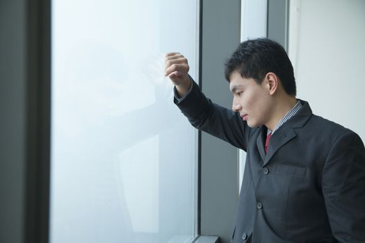 Businessman looking through window in office