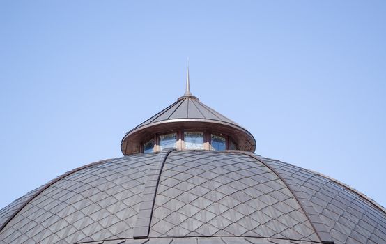 zodiac signs symbols under small retro building iron tiled roof on background of blue sky.