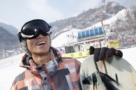 Smiling Snowboarder in Ski Resort