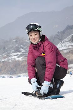 Smiling Woman adjusting Ski Boot in Ski Resort