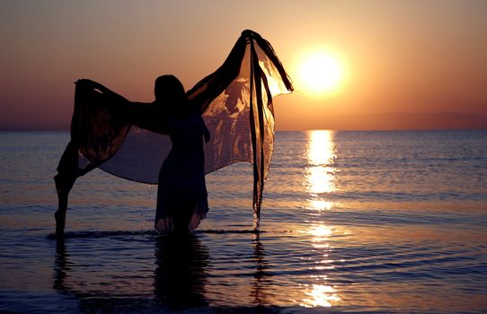 Silhouette of the woman dancing with fiber at sunset beach