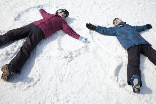 Man and Woman Lying on the Snow Making Snow Angel