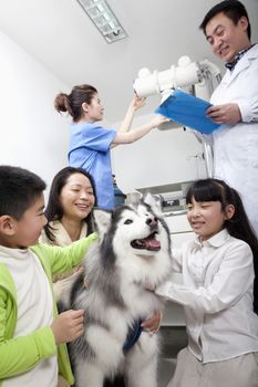 Woman with children and pet dog in veterinarian's office