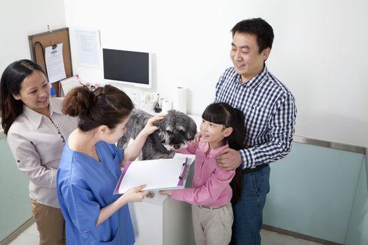 Family with pet dog in veterinarian's office
