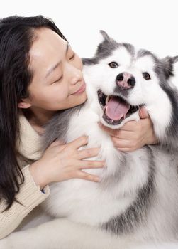 Portrait of woman embracing her dog, studio shot