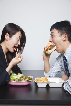 Two young business people eating a meal