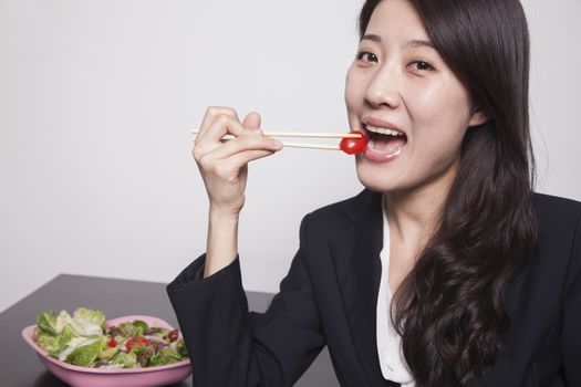 Young businesswoman enjoying a salad, portrait