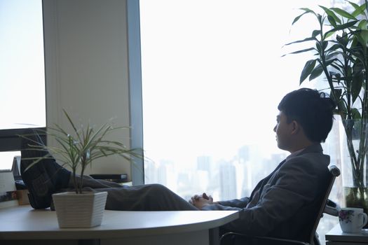 Businessman with feet up looking out the window