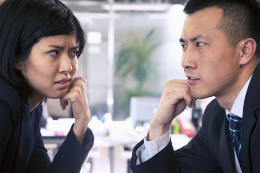 Two Business people staring at each other across a table