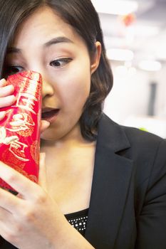 Young businesswomen looking into traditional red envelopment, Chinese New Year