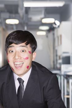 Young Businessman covered in lipstick kisses