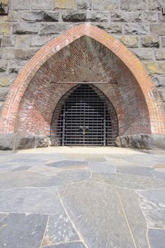 Historic Iron Furnace with Stone Brick Archway and Iron Gate Exterior