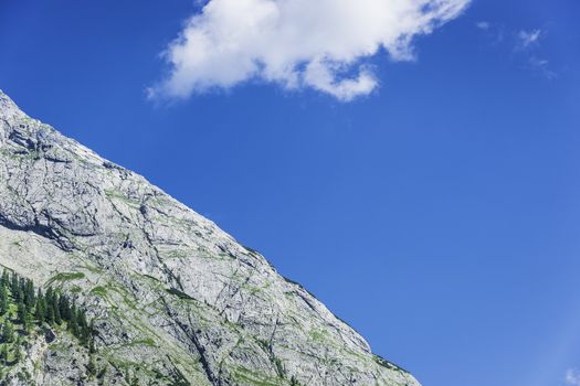 Detail photo of a rocky mountain with blue sky and cloud in the area called Hinterriss in Austria