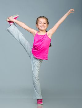 Little girl doing gymnastics exercise in studio