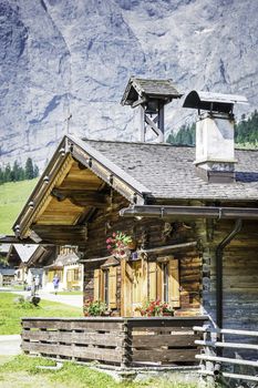 Huts in the Austrian Alps at a place called Hinterriss, Eng on a sunny day with rocky mountains in the background