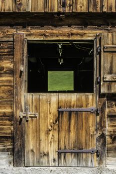 Picture of a wooden door of a stable in the Alps