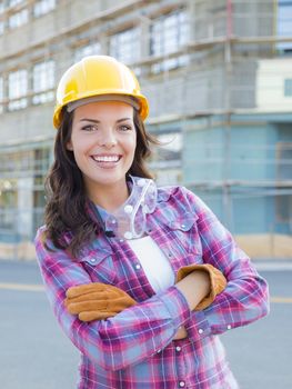 Portrait of Young Attractive Female Construction Worker Wearing Gloves, Hard Hat and Protective Goggles at Construction Site.