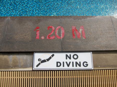 No diving sign and pool depth markings on swimming pool edge