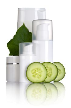 Cosmetic bottles with cucumber slices and leaf on white background
