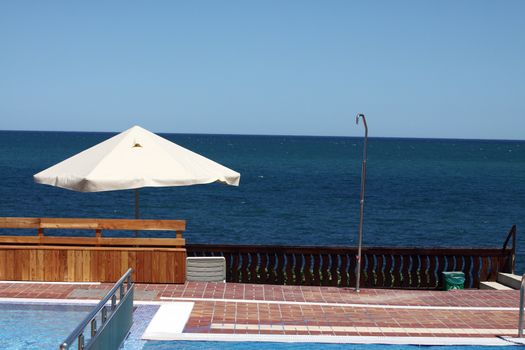 view from the pool with umbrellas near the beach