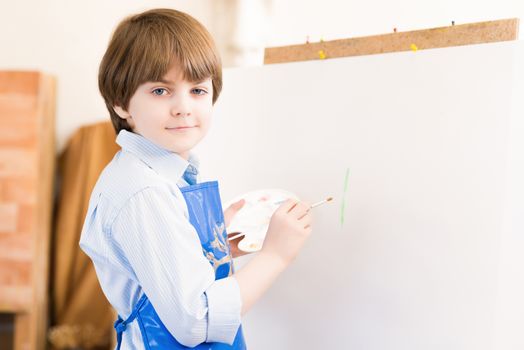 portrait of a boy standing next to his easel, a drawing lesson