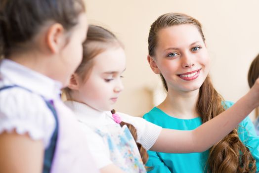 children draw with the teacher in the classroom drawing