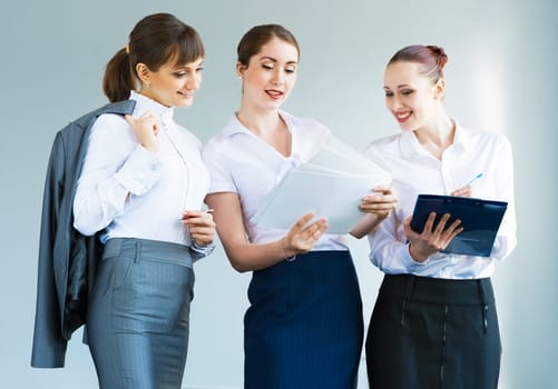 group of business women discussing documents together, teamwork in business