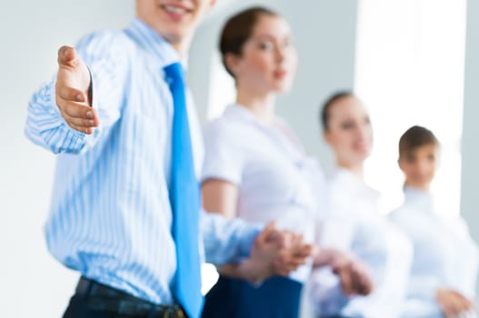 invitation to the team, the business man stretches out his hand, behind him a number of young businessmen