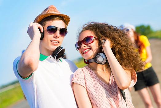 young couple standing on the road, having fun with friends