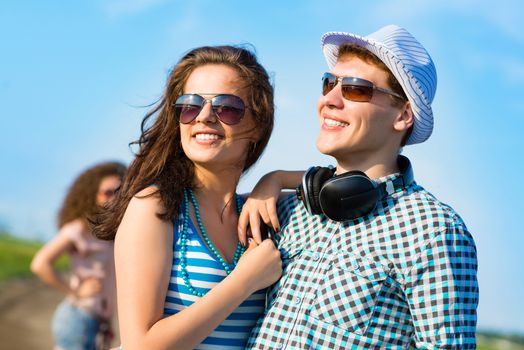 young couple standing on the road, having fun with friends