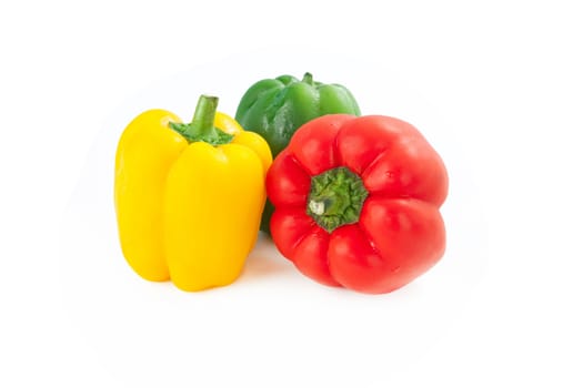 Three sweet peppers in yellow, red and green color on white background