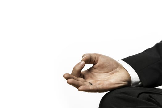 Closeup of the hand of a businessman relaxing in lotus position on a yoga exercise