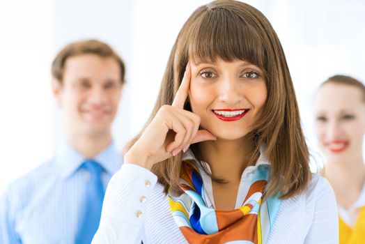 Portrait of a young successful business woman standing against colleagues