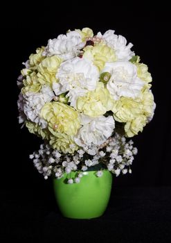 round festive bouquet of yellow carnations on a black background