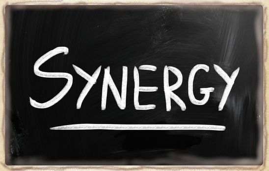 The word "Synergy" handwritten with white chalk on a blackboard