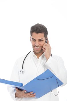 Handsome young male doctor speaking on his mobile phone while holding an open blue file in his hand isolated on white
