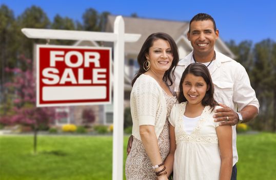 Hispanic Mother, Father and Daughter in Front of Their New Home with Sold Home For Sale Real Estate Sign.