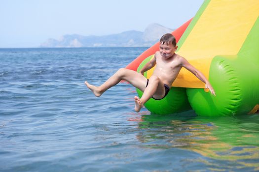 Happy boy sliding down a waterslide in sea