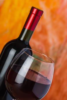 Wine, glass and the bottle on a colored background