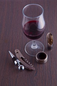 A glass of wine and tools for wine on a table