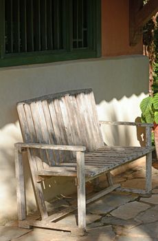 Rustic or distressed bench for a seating area outdoors in the summertime with nobody