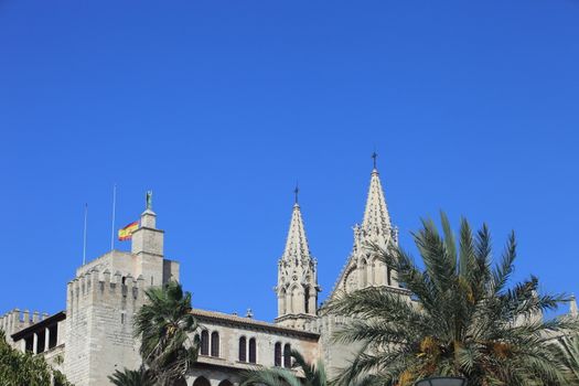 Twin spires of La Seu Cathedral, Majorca in the Balearic Islands above tropical palm trees on a summer vacation