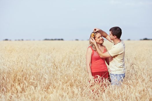 Guy catches a flower girl in a wheat field