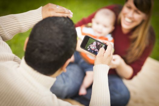 Happy Mixed Race Parents and Baby Boy Taking Self Portraits Outside at the Park.